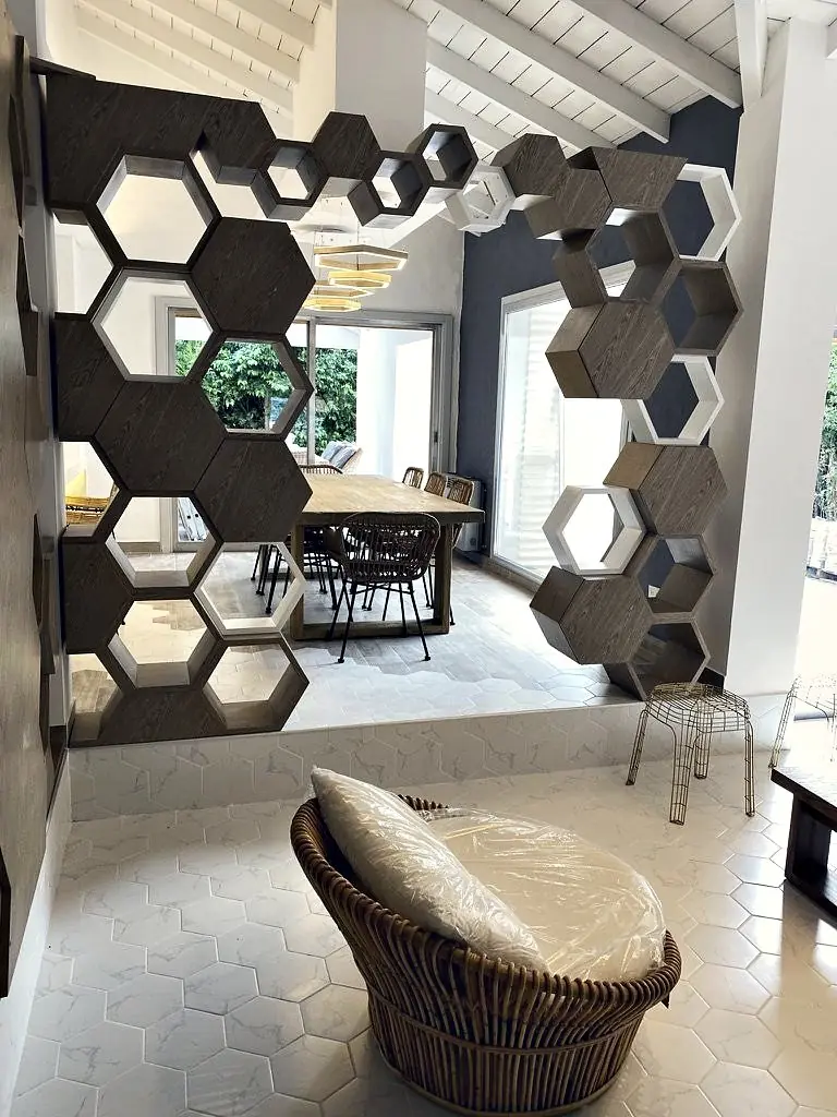 Divisor de hexágonos de madera y piso de hexágonos blancos en la vivienda AVNZ