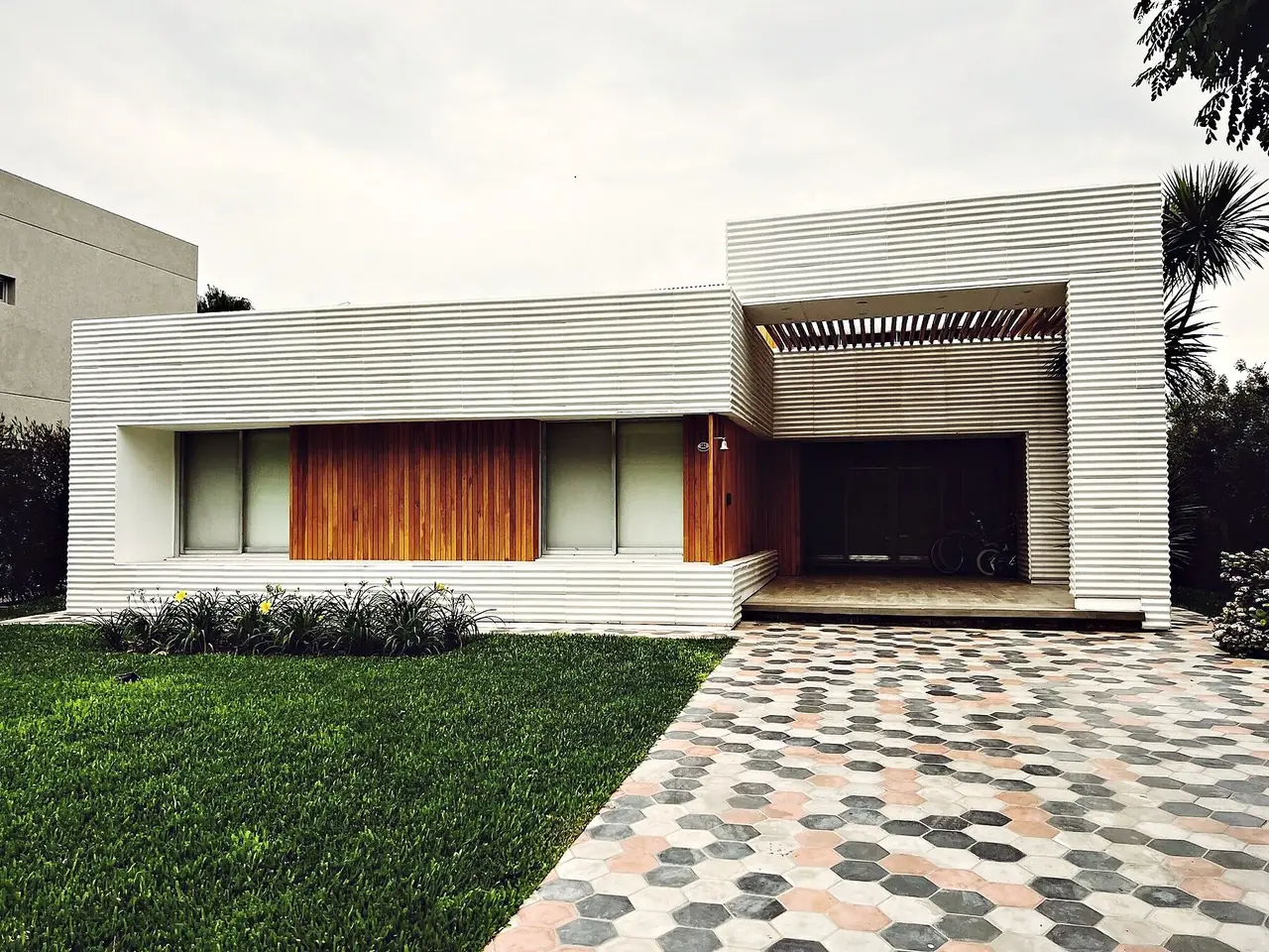 Vivienda de chapa blanca y madera con solado de hexágonos