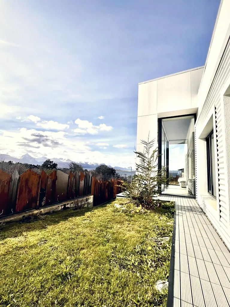 Deck y jardín con cerco de corten, el canal Beagle y la cordillera al fondo