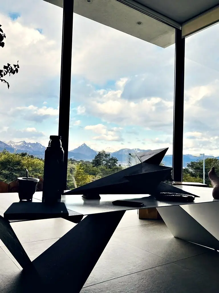 Mesa de hierro plegado con mate frente al ventanal y la cordillera