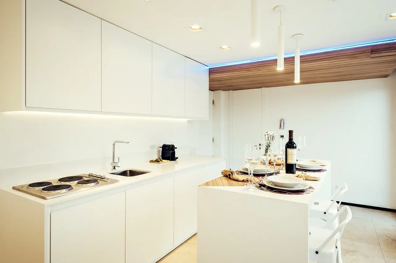 Cocina blanca de una unidad de Original House con cielorraso de madera
