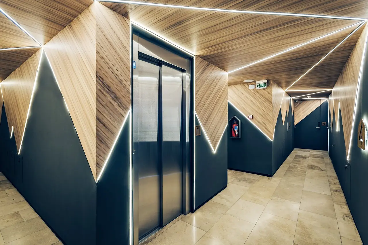 Pasillo de Original House: madera plegada con líneas de luz LED