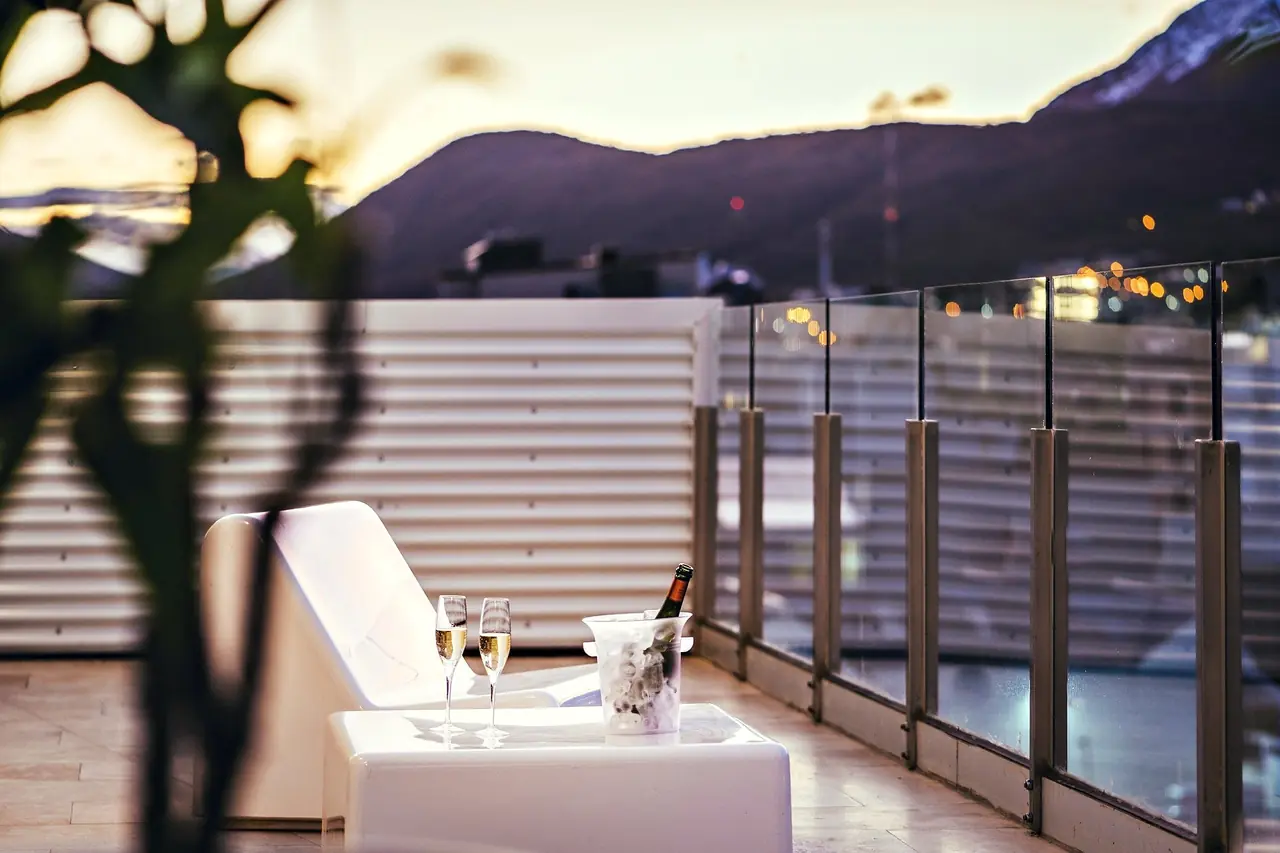 Terraza al anochecer con copas y la cordillera al fondo